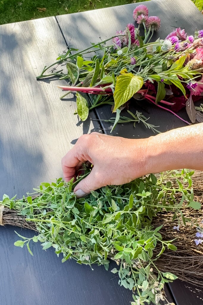 adding greenery to cinnamon broom
