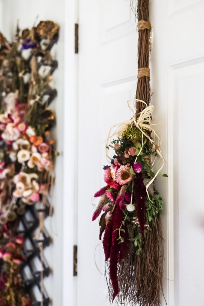 floral witch broom hanging on a door