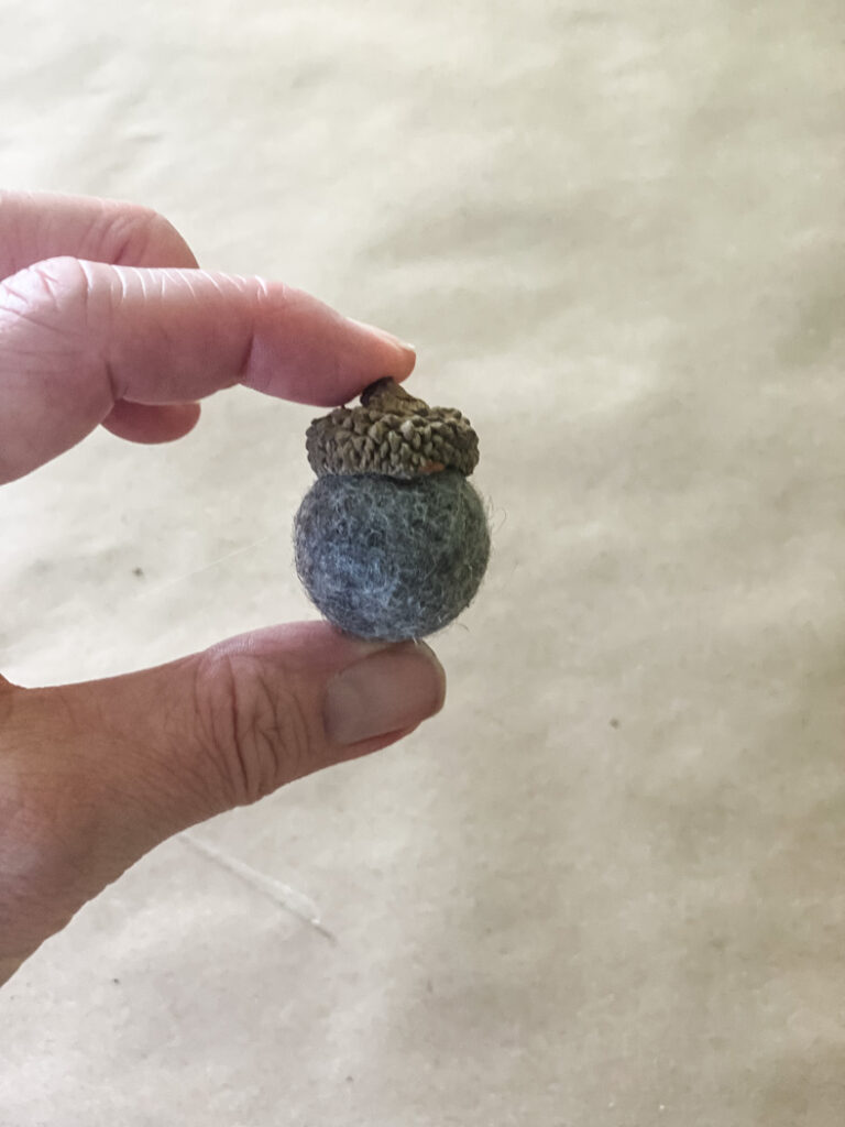 holding a felt diy acorn