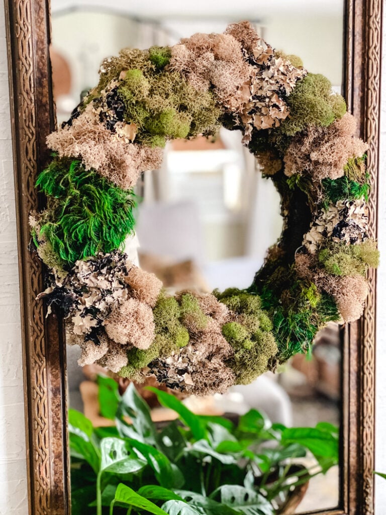moss wreath hanging on a mirror
