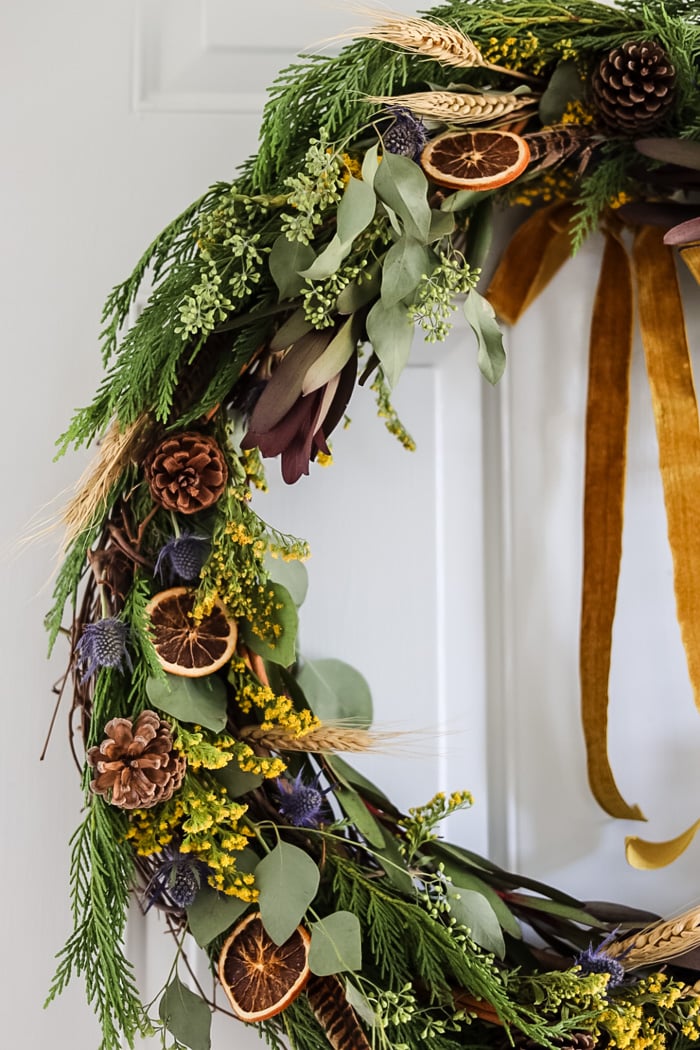 detailed image of half of a wreath decorated with flowers and dried oranges