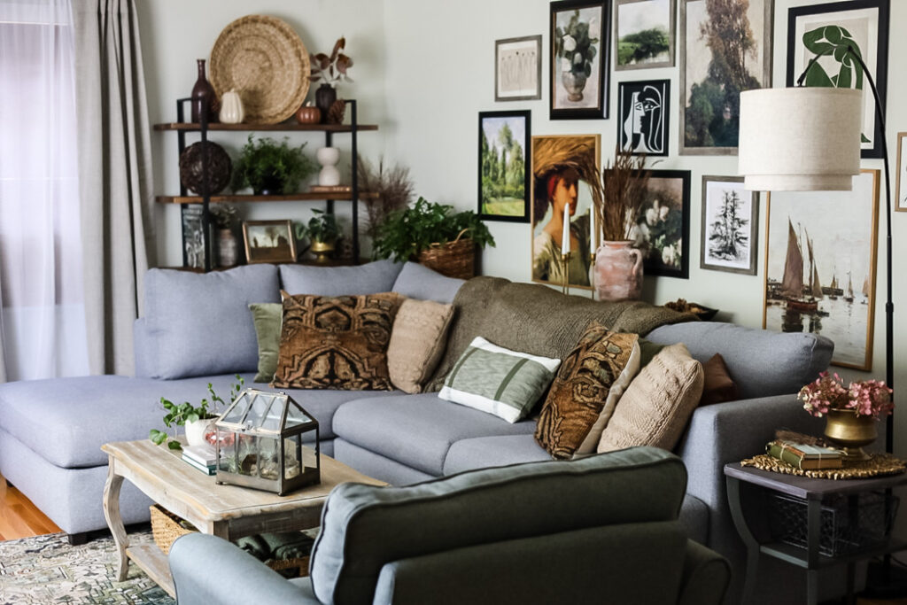 living room view decorted for early fall in warm colors w large gallery wall