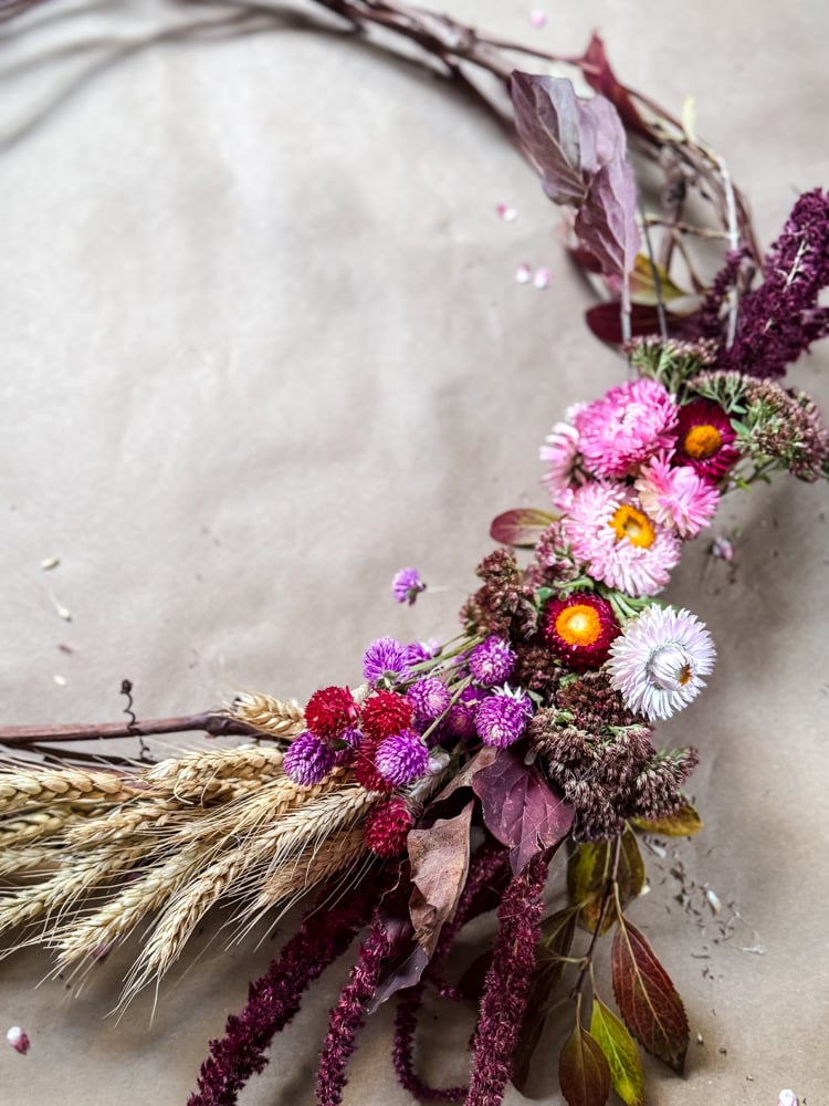 overhead photo of a colorful wreath made with garden flowers