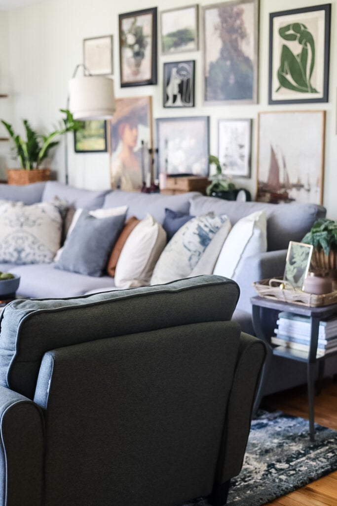 back view of a green chair looking into a living room with large gallery wall