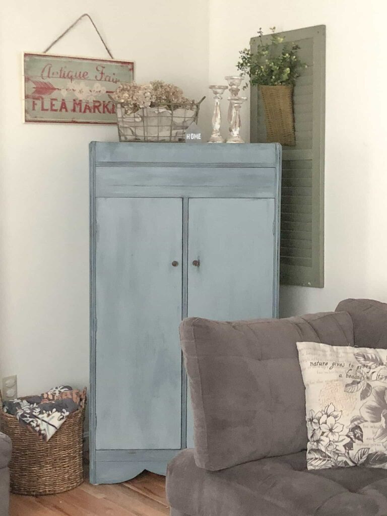 blue cabinet in corner of living room