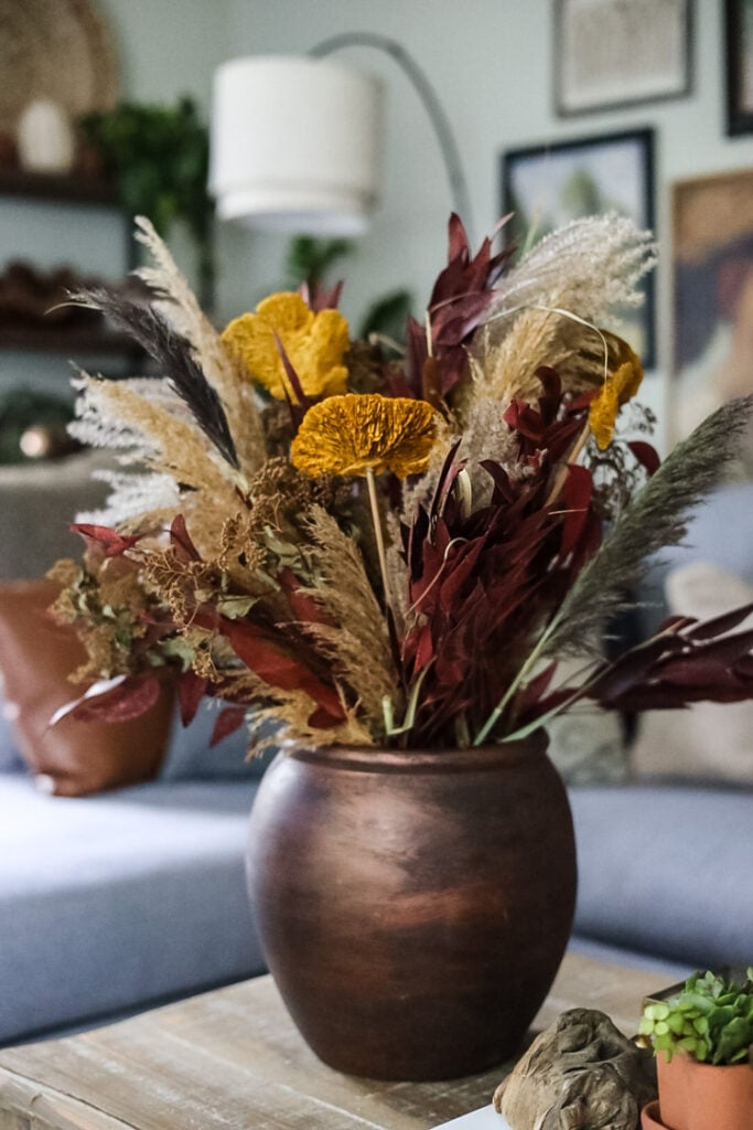 dried flowers and grasses in bronze color vessel