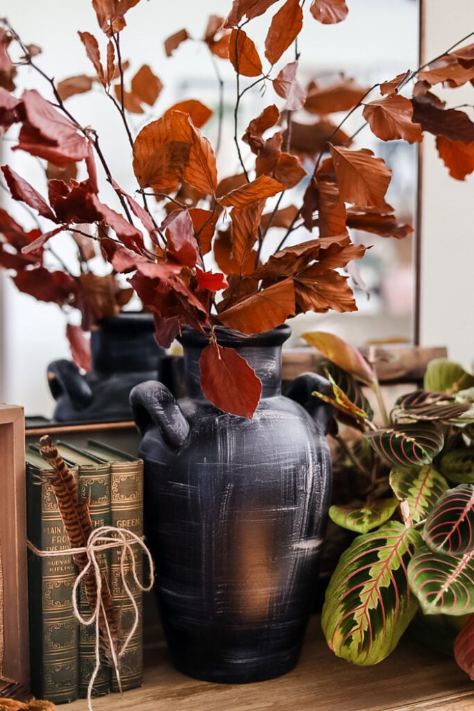 dried leaf stems in black vase