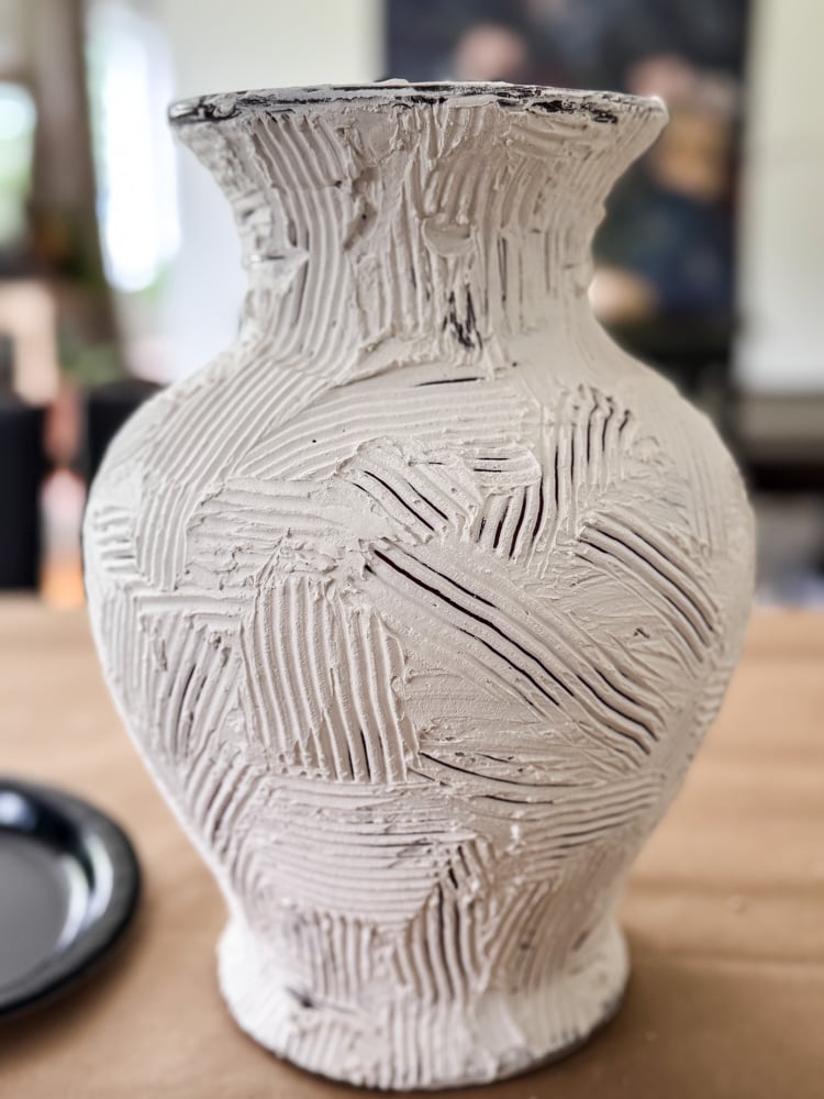 a vase covered in joint compound that has been textured with a comb like tool